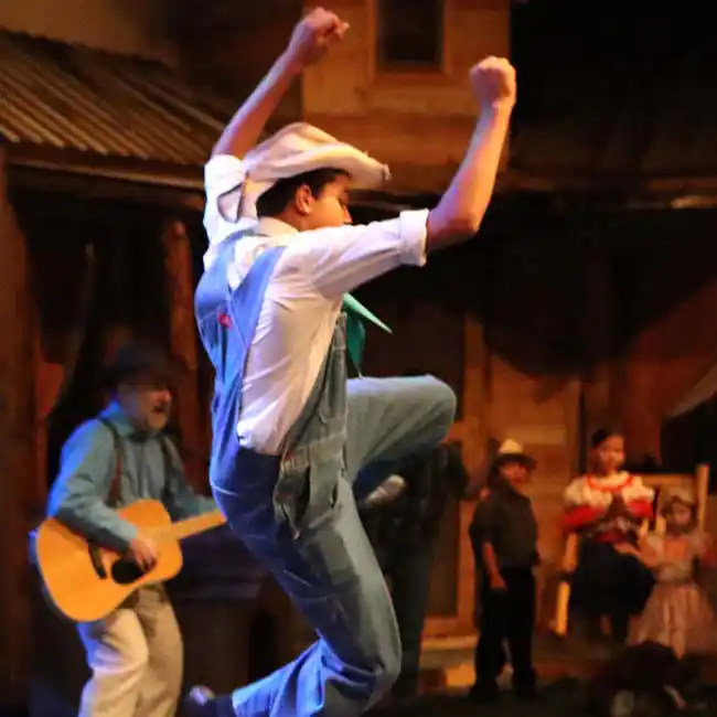dancer jumping in overalls