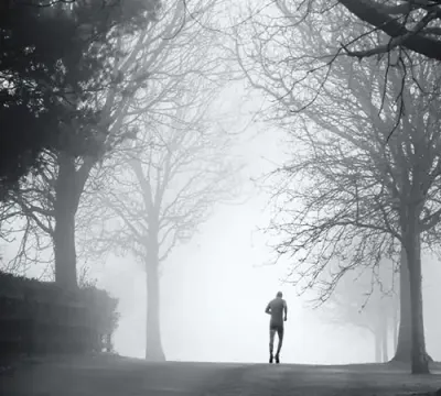 man running alone on foggy road